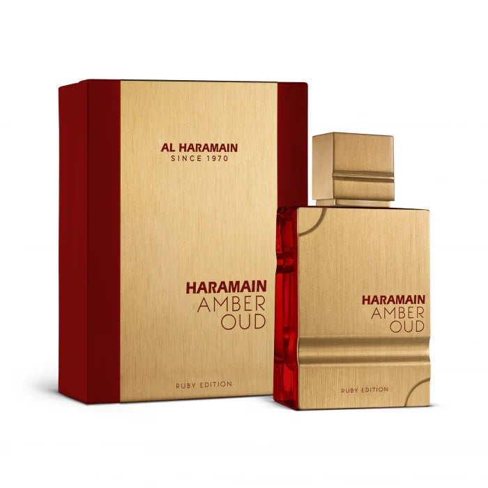 A stunning presentation of Al Haramain Amber Oud Ruby Edition, featuring its luxurious golden bottle with vibrant red accents, alongside the matching gold and red box.